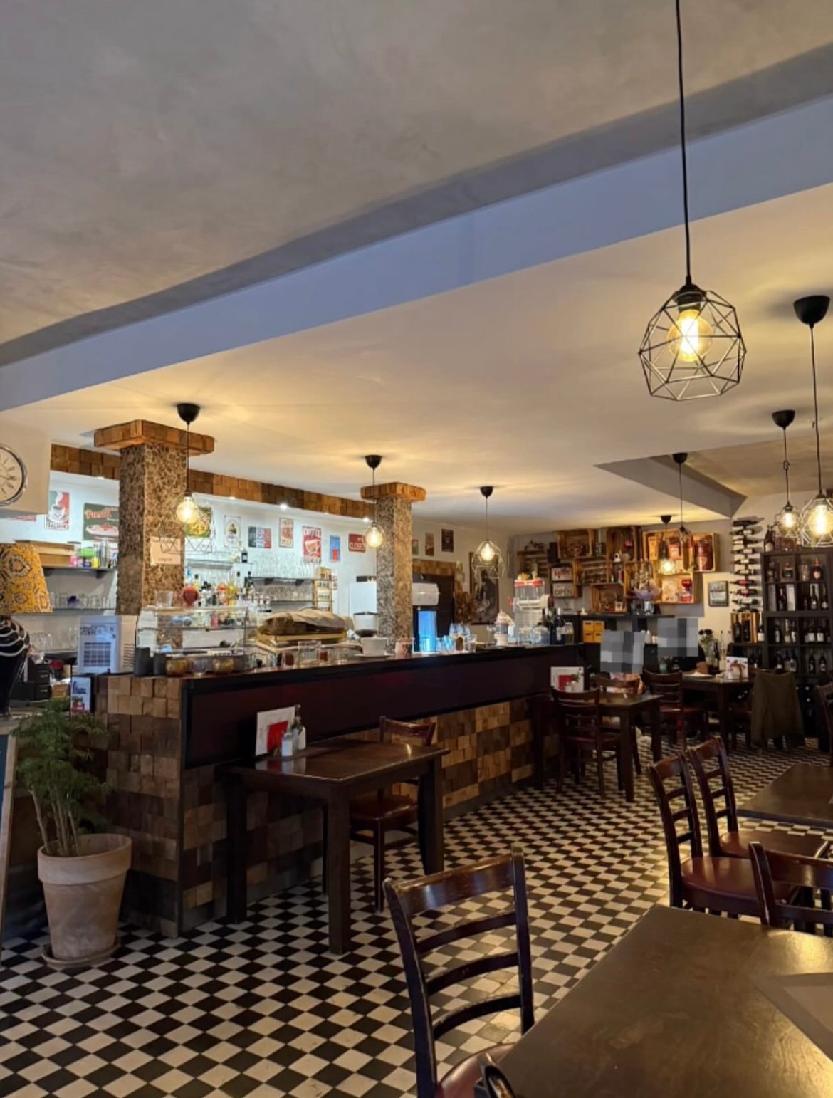Gastraum der Trattoria Café Centrale mit Fliesenboden und Bar