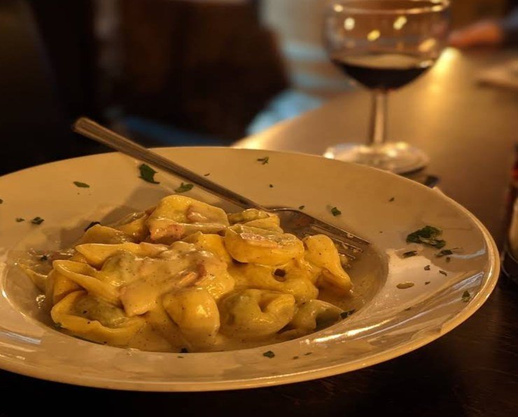 Hausgemachte Pasta mit einem Glas Wein in der Trattoria Café Centrale